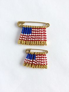 two red, white and blue pins sitting next to each other