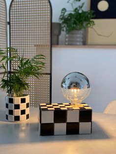 a glass ball sitting on top of a table next to a potted plant