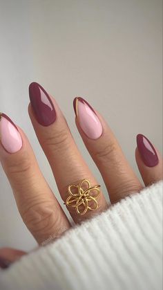 a woman's hand with some pink and gold nail polishes on her nails