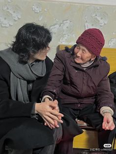 two women sitting next to each other on a bench