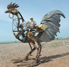 a man sitting on top of a metal bird sculpture