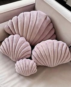 three scallop shaped pillows sitting on top of a couch