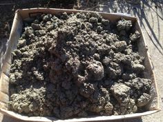 a box filled with dirt sitting on top of a sidewalk