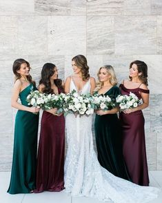 the bridesmaids are all wearing different colored gowns and holding their bouquets