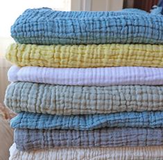 a stack of folded towels sitting on top of a bed