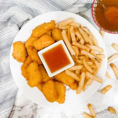 a white plate topped with french fries and dipping sauce next to a bowl of ketchup