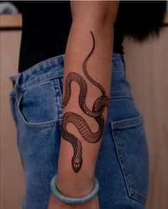 a woman's arm with a tattoo on it, and a snake in the middle