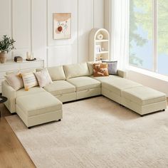 a living room with a large sectional couch and white carpeted area rugs on the floor