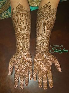 two hands with henna tattoos on them, one is showing the intricate pattern and the other has an elaborate design