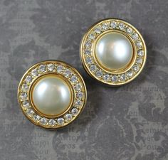 A pair of classically stylish S.A.L. designer vintage gold tone round clip on earrings. They are centered with faux pearls with a ring of sparkling clear rhinestones.  Signed S.A.L. on the back. In excellent condition.  Measurements 1" or 2.5 cm wide Vintage Earrings: https://www.etsy.com/shop/scdvintage?ref=hdr_shop_menu&section_id=6431611 Shop Home Page: https://www.etsy.com/shop/scdvintage Like SCD Vintage on Facebook for news about vintage jewelry, accessories, housewares and more. Plus new items and special promotions! http://www.facebook.com/pages/SCD-Vintage/186166804752517 1940s Jewelry, A Streetcar Named Desire, Wonderful Life, Designer Vintage, 1940s Fashion, Clear Rhinestones, Shop Home, Vintage Earrings, Clip On