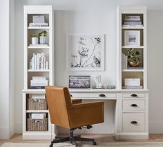 a home office with white bookcases and brown leather chair in front of the desk