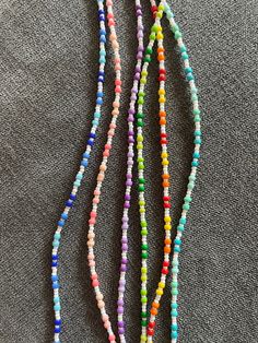 Elevate your style with the vibrant and intricate beauty of our "Radiant Horizons" seed bead necklace. These exquisite pieces are meticulously handcrafted and showcase a stunning array of colours that will add a unique touch of elegance and sophistication to any outfit. Features: - Recycled Materials: Each necklace is threaded on recycled fishing line and all beads come from old jewellery chopped up and upcycled into something new. - Artisanal Craftsmanship: Each necklace is made with precision Adjustable Rainbow Beaded Necklace, Colorful Beaded Necklaces With Spacer Beads For Festival, Colorful Beaded Necklaces With Tiny Round Beads, Colorful Adjustable Necklace With Tiny Beads, Colorful Adjustable Tiny Bead Necklaces, Colorful Beaded Chain Beads For Beach, Colorful Tiny Beads Necklace, Colorful Beaded Chain For Beach, Adjustable Colorful Beaded Necklaces