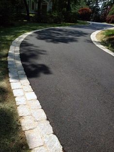 a curved road with white bricks on both sides