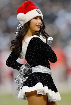 a cheerleader dressed in black and white with a santa hat