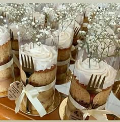 there are many desserts on the table with forks in each cupcake, which is decorated with baby's breath flowers