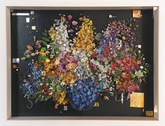 an art work with flowers on display in a frame