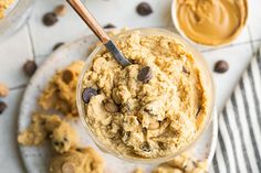 peanut butter and chocolate chip cookie dough in a glass bowl with a spoon on the side