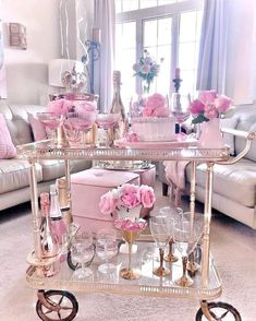 a living room filled with lots of furniture and pink flowers on top of a table