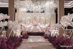 an elaborate wedding setup with flowers and chandelier