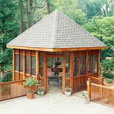 a wooden gazebo surrounded by greenery and trees