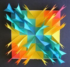 an origami square with many different colors and shapes on the top, as if it were folded in paper