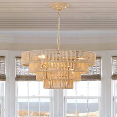 a chandelier hanging from the ceiling in front of two windows with bay windows