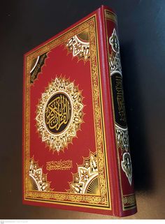 the book is red and gold with arabic writing