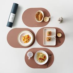 three plates with food on them are sitting on a table next to a bottle of wine