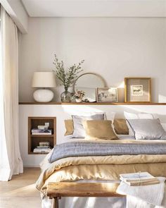 a bed sitting in a bedroom next to a wooden shelf filled with pictures and plants