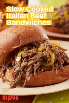 a close up of a sandwich on a plate with the words slow cooked italian beef sandwiches