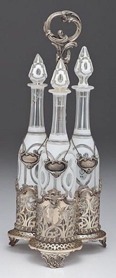 an ornate silver and glass vase with four candles