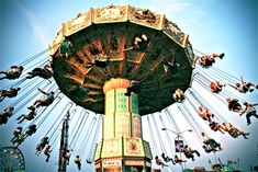 several people are riding on the swings at an amusement park in this photo, there is no image here