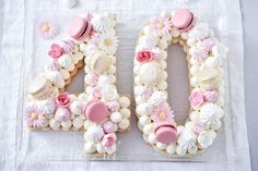 the number 40 is made out of cookies and frosted with pink icing on a white table cloth