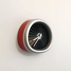 a clock with an arrow on the front and side of it is red, white, and grey