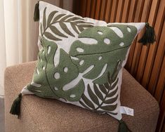 a green and white pillow sitting on top of a couch