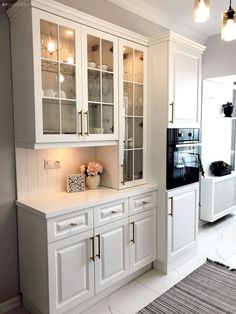 a kitchen with white cabinets and glass doors on the cupboards is pictured in this image