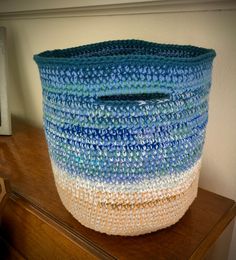 a large blue and white basket sitting on top of a wooden dresser next to a wall