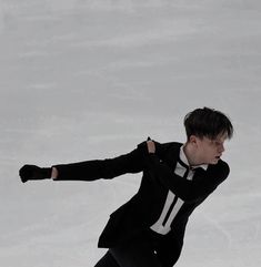 a man in black jacket and tie skating on ice