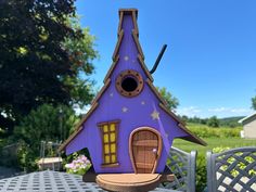 a purple bird house sitting on top of a table