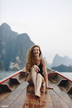 a woman sitting on top of a wooden boat