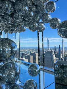 an image of some glass balls in front of the cityscape and skyscrapers