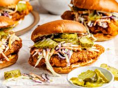 three chicken sandwiches with coleslaw slaw and pickles