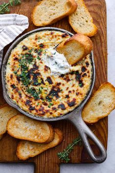 an overhead view of a baked dip in a skillet with garlic bread on the side