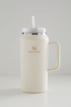 a white travel mug with a straw in it's lid and the name stanley on it