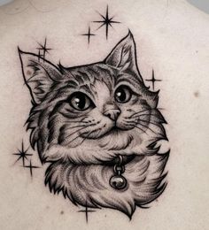 a cat tattoo on the back of a woman's upper arm and chest, with stars in the background