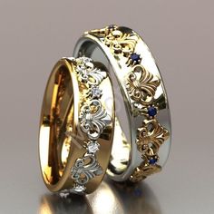 two gold wedding bands with blue stones on each side and an intricate design in the middle