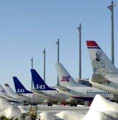 several airplanes are lined up on the tarmac at an airport in snow covered areas