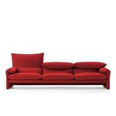 a red couch with two pillows on the back and one pillow on the side, sitting in front of a white background