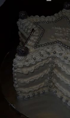 a cake with white frosting and beads on it