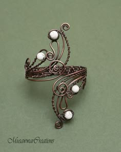 a close up of a brooch with pearls on it's sides and filigrees